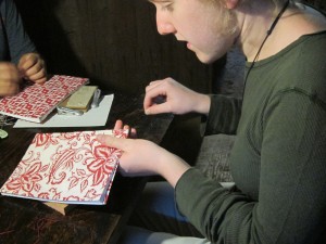 Kayla stitches the binding of her book